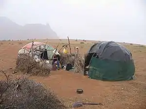 Two huts in an arid landscape