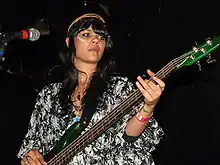 A picture of a woman playing a bass guitar