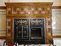 Classical style faience oven surround and tall dado, in the former Grill Room (now called the David Lloyd George Room), National Liberal Club, showing Waterhouse's use of colour in the faience and the simple design of the metalwork on the oven and grill