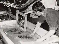 Responders to the flooding of Arno, Florence washing a manuscript.