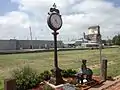 Station clock, with one of numerous statues of children on the grounds.