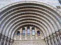 The series of arches above the main entrance, Natural History Museum, note the use of buff and blue-grey terracotta and sculptures, the main sculptures are: a jaguar; a kangaroo; a lioness being constricted by a snake; an American brown bear; a hyena.