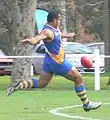 Nauruan player kicks the ball downfield