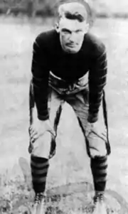 Football player in uniform, hands on knees