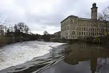 A view looking south over the weir on the River Aire in Saltaire.