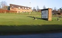 a modern building in an open grassy area, with a sign stating "Cumbria Campus at Newton Rigg" and with the University of Central Lancashire name and logo