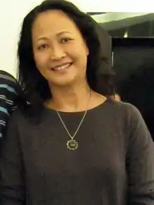 Nhu Quynh in 2010, looking forward and smiling, wearing a grey shirt and a necklace