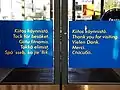 A set of doors in Ivalo's S-Market thanking customers for having visited the store in the domestic languages of Finnish, Swedish, Northern Saami, Inari Saami, and Skolt Saami on the left. Finnish and four tourist languages — English, German, French, and Russian — on the right.