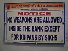 Sign reading "No weapons are allowed inside the bank except for kripans by Sikhs." "Kirpans" is misspelled as "kripans".