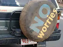 A tire cover on the back of an SUV displays the slogan.