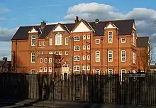 A large red and yellow brick school of a similar Gothic design to the previous photographs of houses but on a much larger scale