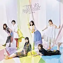 6 women pose with the large-size colorful cellophanes. The top of the cover shows the title "ごめんねFingers crossed" and the group's name "乃木坂46" in purple font.