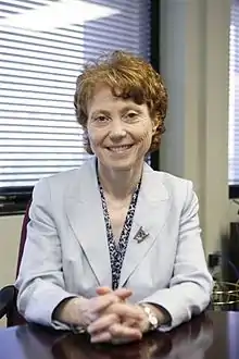 Nora Newcombe sitting at her desk, hands folded, at Temple University