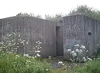 A rear view of an eastern Command Type pillbox showing the huge blast wall covering the entrance.