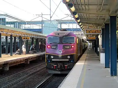 A diesel locomotive with a passenger train at a station