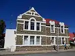 Double-story stone building.
Main facade comprises triangular main gable with Palladian windows below; there is a pair of split rectangular gables over each of the other windows.
There are split semi-circular gables over the side windows, which exist in pairs.
Louvred lantern roof ventilator.
Building opened 10 October 1879 but the Girls' Public School opened 15 July 1891.
An east wing for the nursery school was added in 1897 and opened in 1899.
It is a fine example of Victorian public architecture.
Type of site: School
Previous use: School.
Current use: Municipal offices.