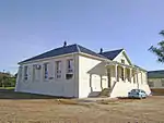 Neat and substantial late Victorian school building.
This building, which was erected in 1905 by the Dutch Reformed Church at a cost of £2000.
was the first true school building in the town.
In 1906 the school opened with 209 scholars and a staff of five.
Since 1962, after the transfer of the remaining scholars to the new school, the building has been used for community functions.
Type of site: Educational
Previous use: School.
Current use: Offices.