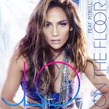 The cover art for the single, featuring a full-face view of a light-brown-skinned woman (Jennifer Lopez) posing before what appear to be white plastic curtains. She's wearing make-up, clothes and jewelry suitable for a night at the disco. Her blue party dress leaves her arms, parts of her waist and top of her chest bare. She has several silvery chains around her neck. Her hair is streaked light and dark brown and hangs down carelessly to her shoulders and below. Large, multi-colored letters in the foreground read "JLO". Sideways on the right edge are the somewhat smaller words in blue, "ON THE FLOOR" and "FEAT. PITBULL".