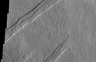 Oti Fossae, as seen by THEMIS. These parallel graben are found on the northeastern side of Arsia Mons; they are in line with the NE/SW trend of the three volcanoes in Tharsis.