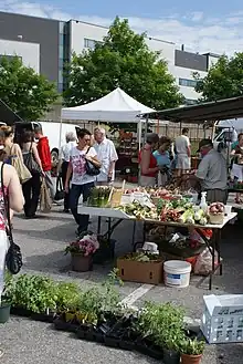 A display of fruits/vegetables in a crowd outside.