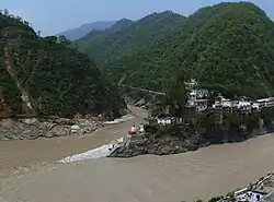 Confluence of Alaknanda (bottom, from right) and Mandakini River (flowing from top - North) at Rudraprayag.  Before 17 June 2013, there was a footbridge (jhula) over the Mandakini; this was washed away in the 2013 Uttarakhand floods.  The stones at the bottom of the stairs were not there; instead, there was a viewing platform, and a large rock called Narad Shila.