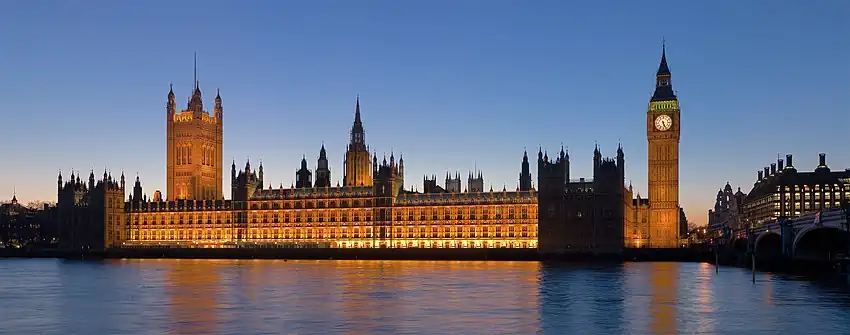 A modern photograph of the Palace of Westminster at night from across the River Thames