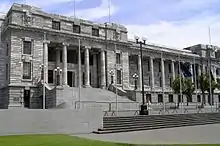 Edwardian neoclassical building in grey stone with classic colonnade entry on grand stairs