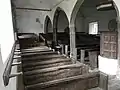 The interior of St Petrock's from the front of the south aisle. Note the hat pegs on the wall on the left