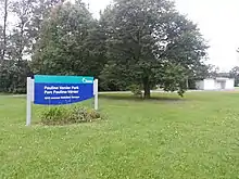 Park sign. The park pavilion can be seen in the background, to the right.