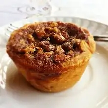 A Butter tart is a type of small pastry tart highly regarded in Canadian cuisine and considered one of Canada's quintessential desserts. The tart consists of butter, sugar, syrup, and egg filled into a flaky pastry and baked until the filling is semi-solid with a crunchy top.