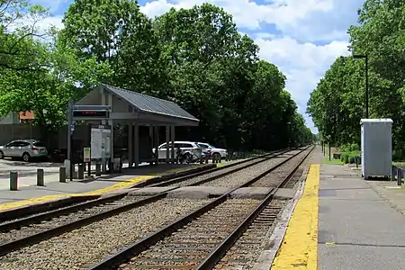 Two track-level platforms next to a two-track railway line