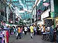 Row of shops and hawkers underneath the "Green Dragon"