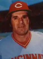 A baseball player in a grey uniform and a red hat.