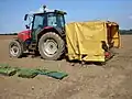 Five-row transplanter being towed by a Massey Ferguson 6265 tractor.