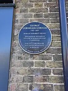 Plaque which reads 'George Cornelius Gorham 1787-1857 Born at 22 Market Square Theologian, historian, fellow of Kings Colledge Cambridge One of 12 children of a St Neots merchant & banker'