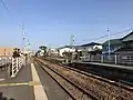 A view from platform 1 with platform 2 to the right. The level crossing can be seen in the background.