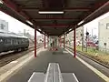 Another view of the platform. Beyond the waiting room, the level crossing can be seen in the distance.