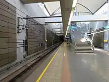 Concrete underground island platform with light entering from windows high up