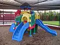 Combination playground structure for small children; slides, climbers (stairs in this case), playhouse