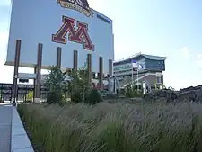 Large sign saying "M", towering above a field of long grass