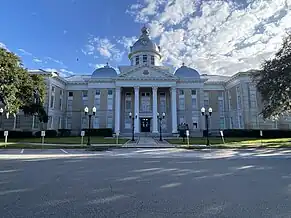 Large, white government building photographed from across the street