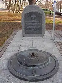 Eternal flame and commemorative plaque adjacent to the monument