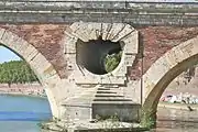 The bridge is equipped with crests in front of each pier to separate the flows, and openings allowing water to pass through even when it reaches the top of the arches.