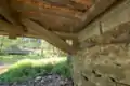 The underside of the bridge showing where the Burr arch meets the concrete bridge abutment.  The concrete bridge in the background bypasses this bridge.