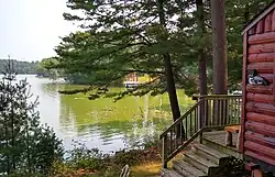 The lake for which the town is named is ringed with cottages. August, with algae in bloom.