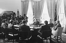 A meeting of Nixon Administration economic advisors and cabinet members on May 7, 1974. Clockwise from Richard Nixon: George P. Shultz, James T. Lynn, Alexander Haig, Roy Ash, Herbert Stein and William E. Simon.