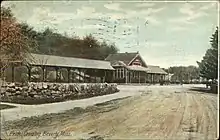 A postcard view of a small railway station with canopies over the platform