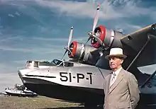 In suit, standing in front of a line of PBY Catalina seaplanes of patrol squadron VP-51