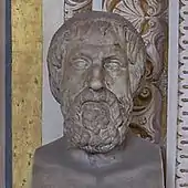 Bust of a somewhat elderly and rather tired-looking man with a short, curly beard, vaguely similar to Greek busts of Homer