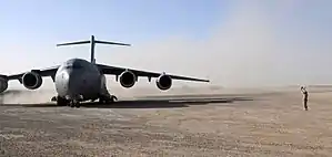 Four-engined jet transport plane on dirt airfield